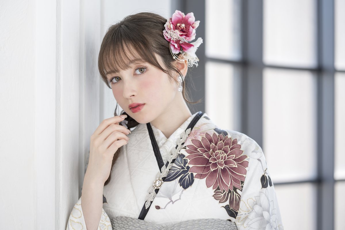 白地に花柄の振袖をまとった成人女性のポートレート