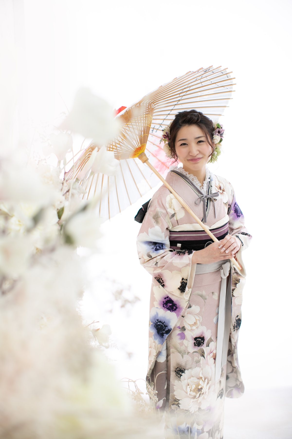和傘を手にした淡い振袖姿の成人女性